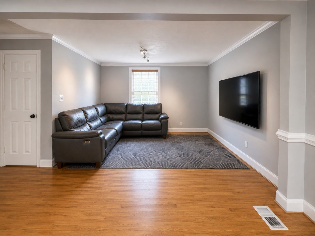 Living room with mounted TV and leather sectional